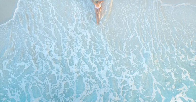 Remote Trips - Anonymous female traveler resting on sandy sea shore