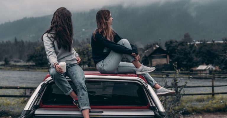 Fall Trips - Two Women Sitting on Vehicle Roofs