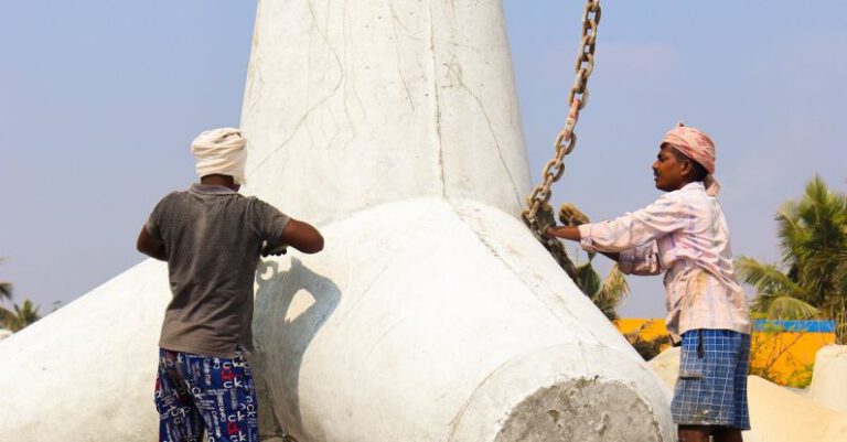 Chain Lubrication - Two men are working on a large concrete sculpture