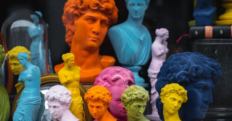 Cultural Differences - Multicolored head sculptures of David near bright statuettes placed in store with abundance of souvenirs and black pillar with book