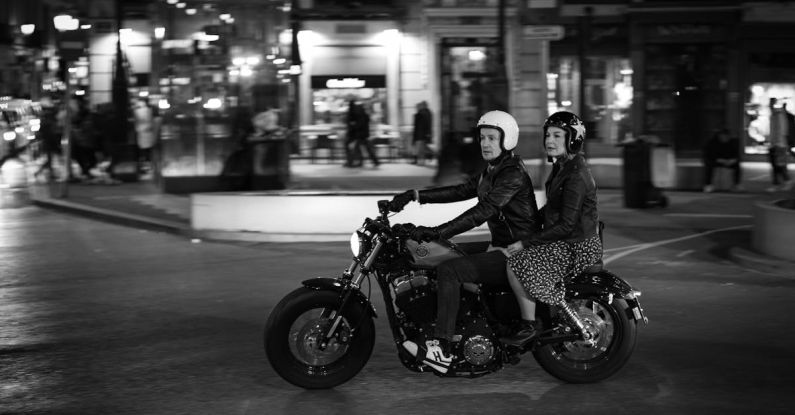 Night Riding - A couple riding a motorcycle on a city street